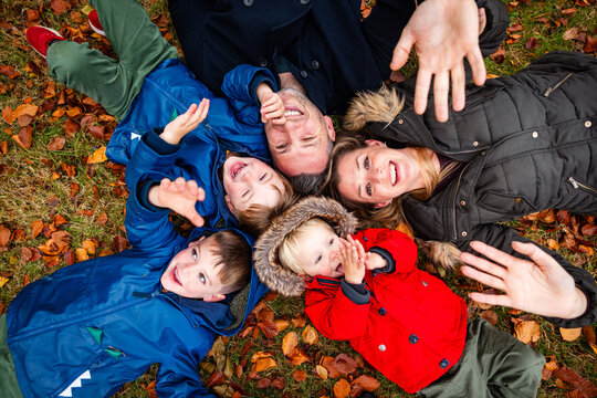 Happy family lying in autumn leaves smiling together