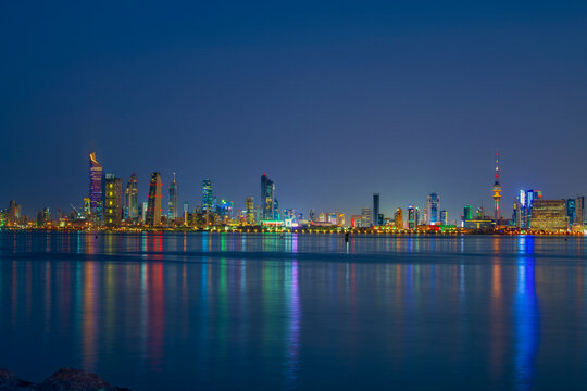 Kuwait City Skyline at Blue Hour Reflected in the Arabian Gulf Waters at Dusk. Kuwait City skyline view.