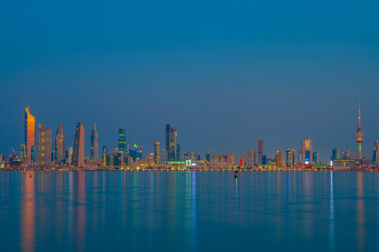 Kuwait City Skyline at Blue Hour Reflected in the Arabian Gulf Waters at Dusk. Kuwait City skyline view.