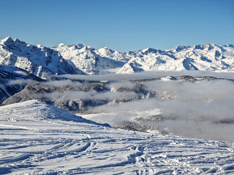 Snow-covered mountain range above misty alpine valley