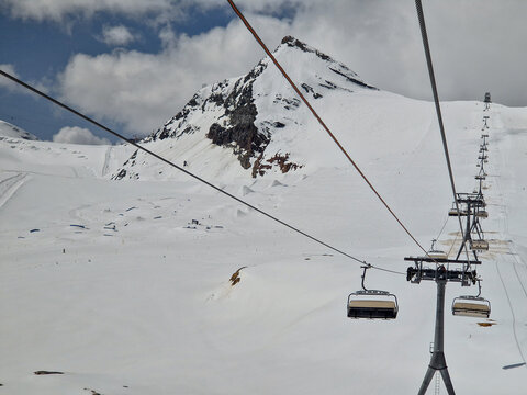 Ski lift beneath snow-covered mountain in winter resort