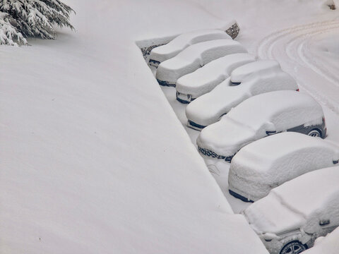 Snow-covered car in a winter parking lot