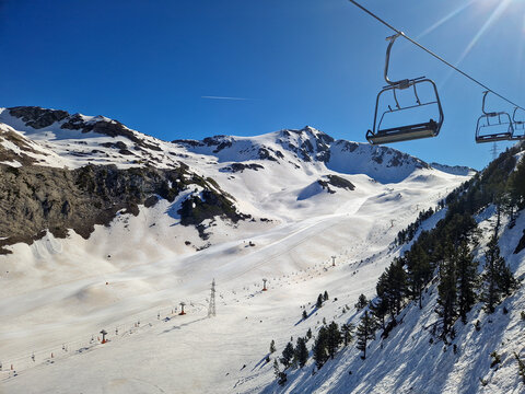Snowy mountain ski resort with chairlift under blue sky