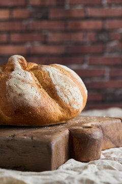Rustic artisan bread loaf on wooden table in bakery