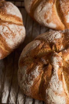 Rustic artisan bread loaves on a bakery rack