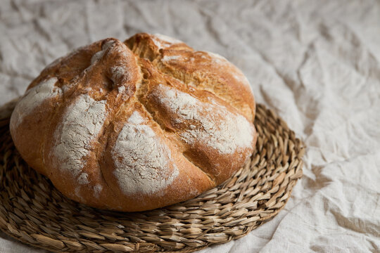Rustic artisan bread loaf on woven rattan placemat