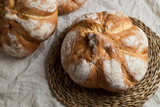Rustic artisan bread loaf on a woven rattan base