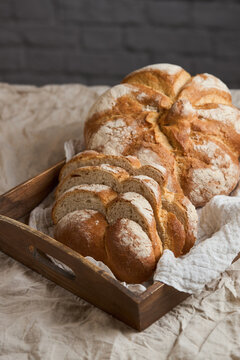 Rustic bakery loaf with sliced artisan bread in wooden tray