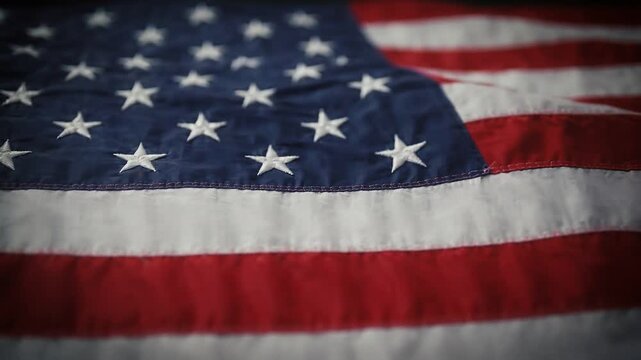 Close up slow motion of american flag waving gently in wind, stars and stripes creating patriotic background for national events, memorial day or 4th of july celebrations.