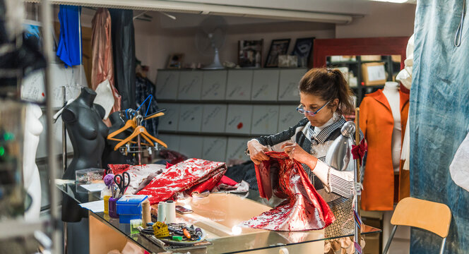 Fashion designer crafting handmade dress in atelier workshop