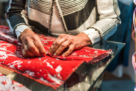 Tailor hand stitch red fabric in a fashion workshop