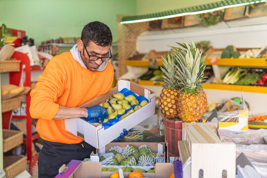 Shop worker arrange fresh fruit at local market stall