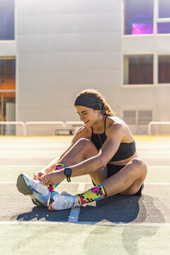 Female athlete tie shoe lace on outdoor running track