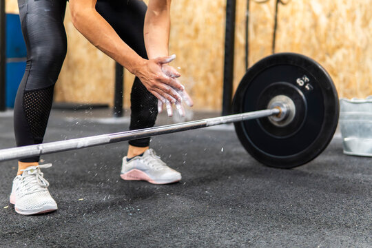 Athlete prepare for barbell lift with chalked hands