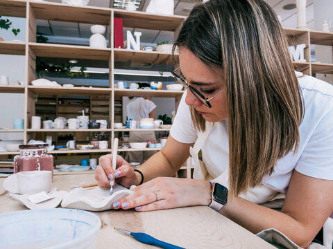 Woman craft handmade ceramic piece in pottery workshop