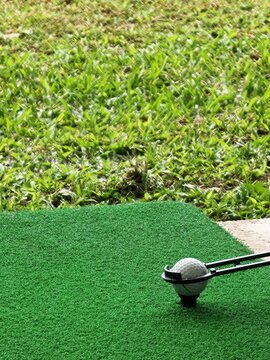 Vertical Golf Ball on Tee with Grass Backdrop and Copy Space