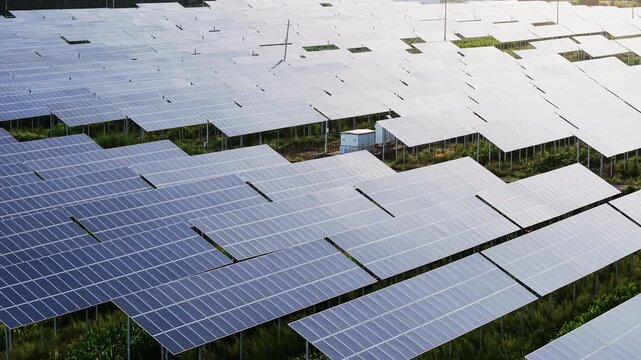 Vast solar panels array in a photovoltaic farm panning right. Geometric clean energy infrastructure, ideal for ESG, renewable technology, and sustainable environment projects.