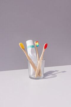 Bamboo toothbrush and toothpaste in glass cup
