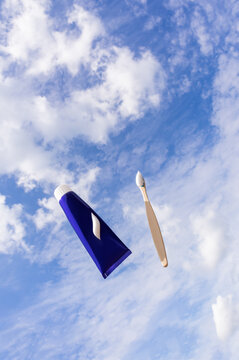 Toothpaste and bamboo toothbrush against blue sky