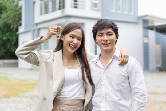 Happy couple showing house key after buy home success