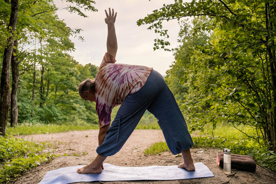Mature man practice yoga outdoors for healthy aging wellness