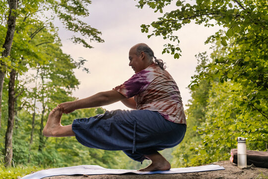 Mature man practicing mindful yoga outdoors for healthy aging