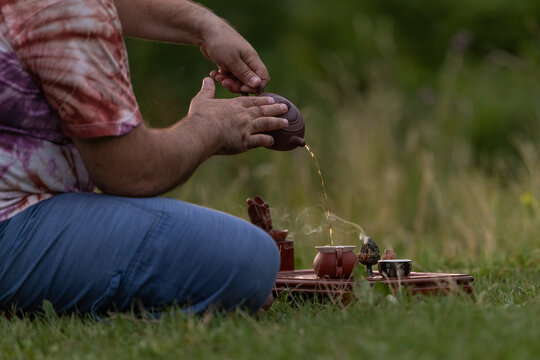 Mature man perform tea ritual for holistic outdoor wellness