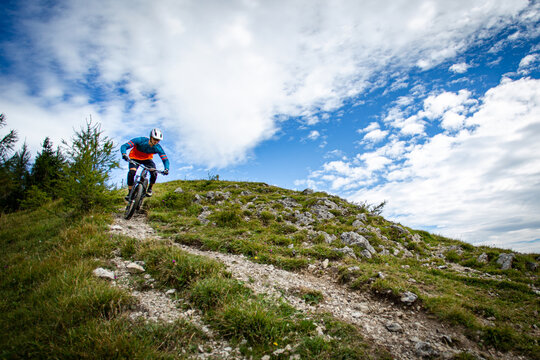 Mountain biker riding across an alpine meadow in the Austrian Alps