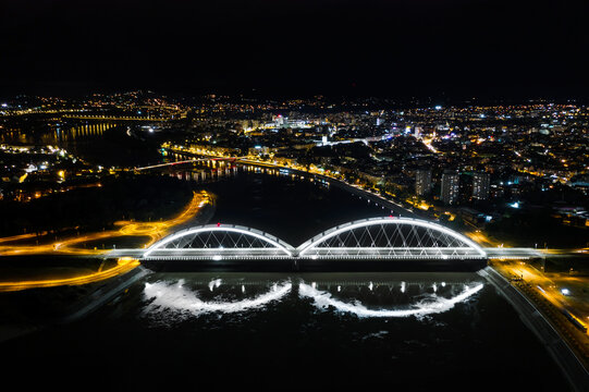 Aerial night view of illuminated bridges over a river.