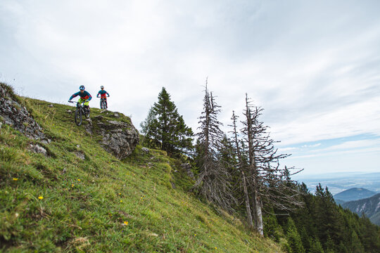 Mountain bikers riding across an alpine meadow in the Austrian Alps