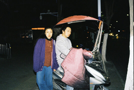 Couple Beside a Motor Scooter at Night