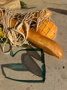 Mesh bag with groceries, and sunglasses