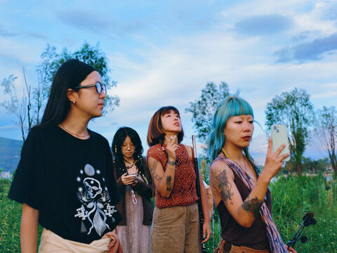 Friends Using Smartphones Outdoors at Dusk
