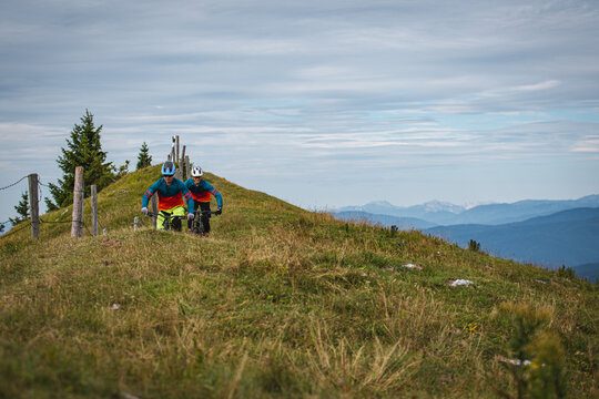Mountain bikers riding across an alpine meadow in the Austrian Alps