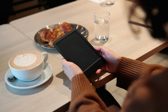 Woman reading on e-reader at cafe