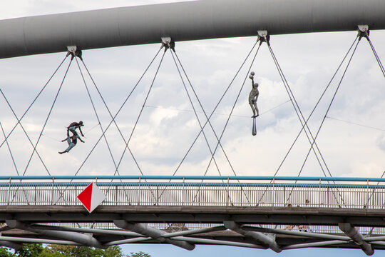 Balancing acrobatic sculptures suspended above the Vistula River on Father Bernatek Footbridge. Created by Polish sculptor Jerzy Kędziora. Suspended across the bridge. Krakow, Poland, June 9, 2026. 