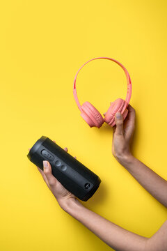 Woman hands holding headphones and portable speaker