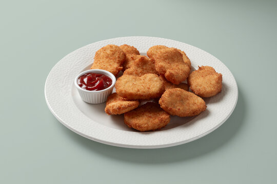 Crispy chicken nugget with ketchup on white plate