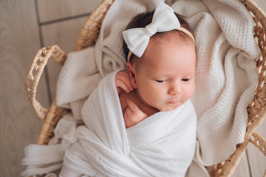 Newborn baby girl resting at home in a wicker basket