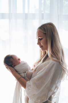 Mother holding newborn baby during first days at home