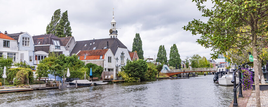 Boats along a canalfront with historic buildings and terraces in Leiden, The Netherlands