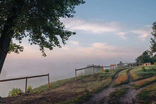 Sunrise over river with country path and tree