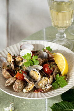 Vongole with tomato, garlic, parsley and lemon on plate