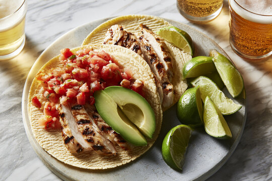 Traditional mexican chicken tacos served with fresh lime and avocado salsa
