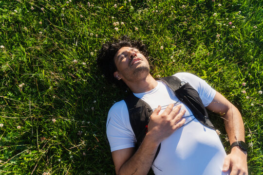 Athlete Resting In Grassy Meadow
