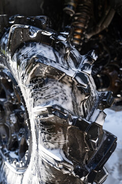Close-up of vehicle wheel wash with soap foam