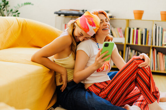 Friends laughing together watching funny video on smartphone