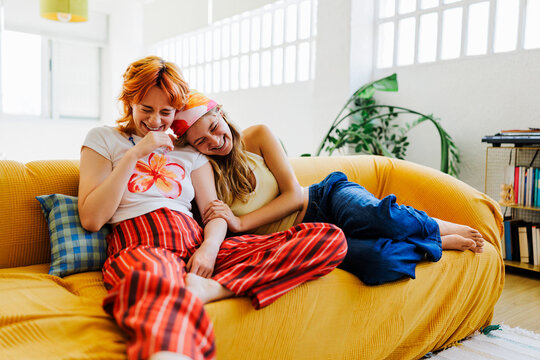 Happy friends laughing together on comfort couch