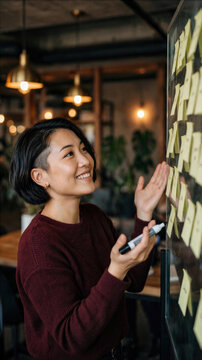 Woman pointing to sticky notes during a team workshop