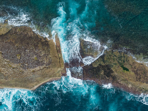 Aerial view of waves over Warden Head coastal rock shelf